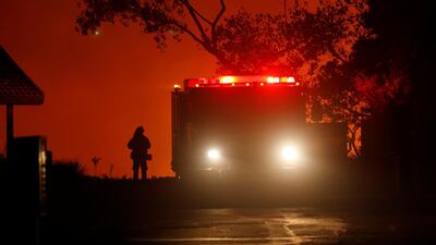 A firefighter waits at the top of a hill to battle a blaze. Mike Blake / Reuters