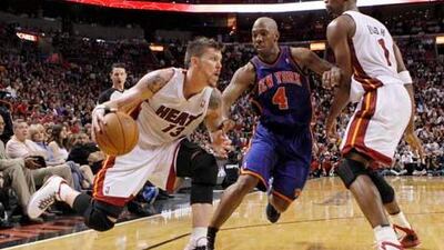 Miami Heat's Mike Miller, left, drives past Chauncy Billups of the New York Knicks as teammate Chris Bosh looks on.