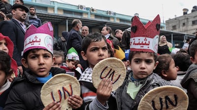 Palestinian children hold bread patties during a protest against aid cuts, outside the United Nations' offices in Khan Yunis in the southern Gaza Strip on January 28. UNRWA. / AFP / Said Khatib
