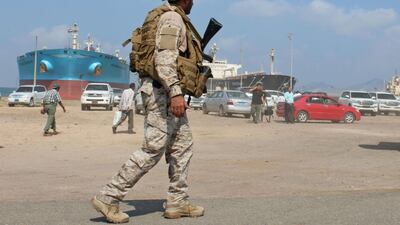 A soldier loyal to Saudi-led coalition forces stands guard near ships docked in the southern Yemeni port of Aden on October 29, 2018. AFP