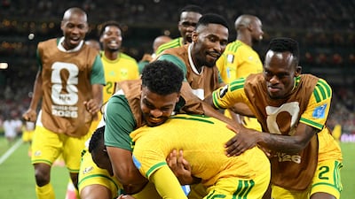 South Africa's forward Thapelo Maseko is hugged by teammates while celebrating scoring his team's first goal during the match between South Africa and South Korea in Guadalupe. AFP