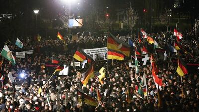 Supporters of anti-immigration movement Patriotic Europeans Against the Islamisation of the West (PEGIDA) hold flags during a demonstration in Dresden January 12, 2015. Fabrizio Bensch / Reuters