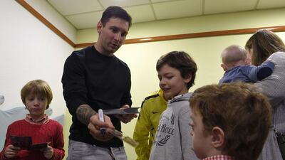 Barcelona’s Argentine forward Lionel Messi signs autographs to children during a charity visit at the Hospital of Barcelona in Barcelona on Monday. Lluis Gene / AFP