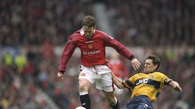 Arsenal's Tony Adams tackles United's Teddy Sheringham in the 1997-98 season. United were runners-up behind the Gunners, with 77 points. Allsport