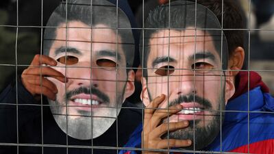 Fans of Nacional wearing Luis Suarez masks. AFP