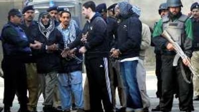 Policemen escort US militant suspects as they leave a court in Sargodha after a hearing yesterday.