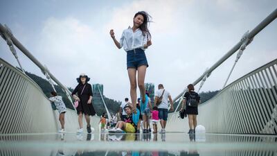 A visitor jumps for a photograph on the world’s highest and longest glass-bottomed bridge above a valley in Zhangjiajie in China’s Hunan Province. Fred Dufour / AFP Photo