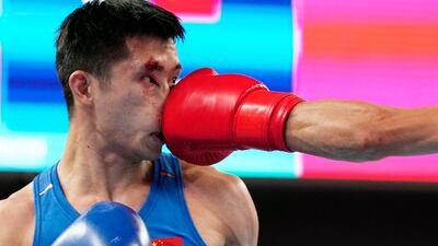 Lyu Ping takes a punch in the men's 51-57kg semi-final at the Asian Games in Hangzhou, China. AP