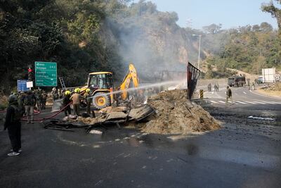 Indian security forces douse a burning lorry, which troops intercepted after its 'unusual movement' on a motorway. AP