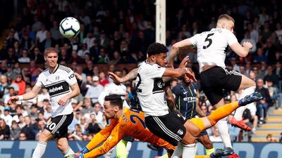Fulham goalkeeper Sergio Rico, center, falls down after punching the ball clear. AP Photo