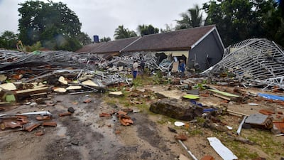 Residents inspect their damaged homes in Carita. AFP