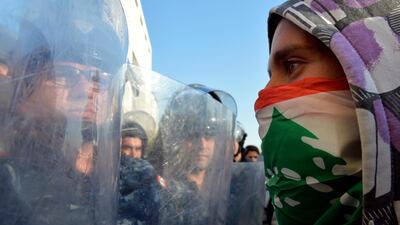 Riot police and a protester face off on a blocked road leading to the Parliament in Beirut. EPA