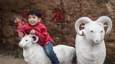 A boy stands on a model of a ram near a temple during celebrations to mark the first day of the Lunar New Year in Hong Kong on February 19, 2015. Philippe Lopez / AFP
