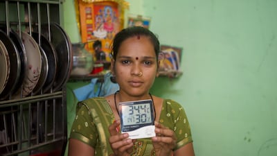 A resident of Indiranagar shows the temperature inside her home, which is yet to be painted