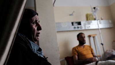 A mother sits with her son who was shot in the leg at the Gaza border by an Israeli sniper during protests against the opening of the US embassy in Jerusalem, at Al Shifa Hospital in Gaza City on May 10, 2018. Getty