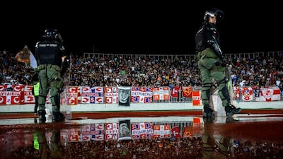 Police officers in front of Red Star supporters. AFP