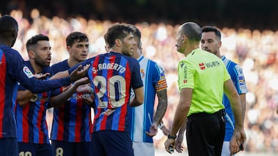 Barcelona defender Jordi Alba, left, argues with the referee after being shown a second yellow card against Espanyol. EPA