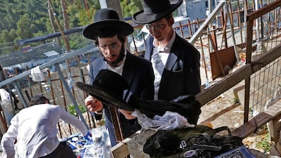 A man checks the personal belongings left at the scene of a stampede that took place during the Jewish religious festival of Lag BaOmer in the northern Israeli town of Meron. AFP