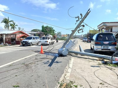 Vehicles manoeuvre next to a toppled electric post in the typhoon-hit town of Balasan, Ilo-Ilo province, Philippines, 26 December 2019. EPA