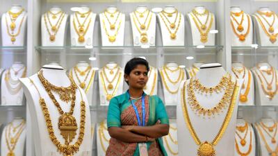 A saleswoman stands next to gold necklaces at a jewellery store in Bangalore. Photo: AFP
