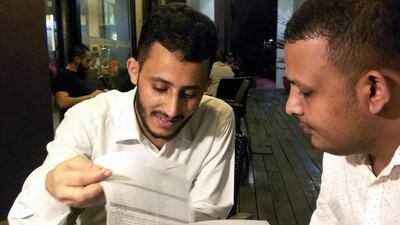 Yemenis Rafek Al Sanani, right, and Abdel Rahman Zaid look through their documents in Serdang, on the outskirts of the Malaysian capital Kuala Lumpur, where they are waiting to travel on to the United States after winning the US government's "green card" lottery. Rozanna Latiff / Reuters / July 20, 2017