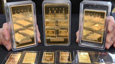 An employee displays gold bars at a Korea Gold Exchange shop in Seoul. The overall demand for gold has declined in the first half this year. AFP