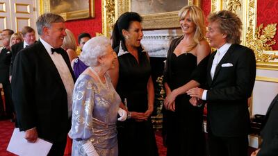 Queen Elizabeth greets singer Sir Rod Stewart during a reception for the Royal National Institute for the Blind at St James's Palace. Getty