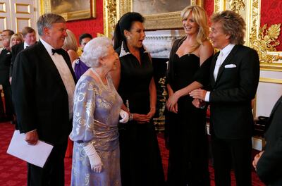 Queen Elizabeth II greets Penny Lancaster and Rod Stewart during a reception for the Royal National Institute of Blind People, at St James Palace on June 3, 2013, in London. Getty Images