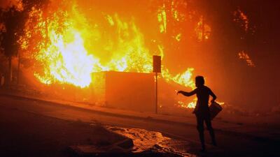 The strong winds and thick smoke kept fire-fighting helicopters and planes grounded at least until daybreak. (Felipe Gamboa / AFP / April 12, 2014)