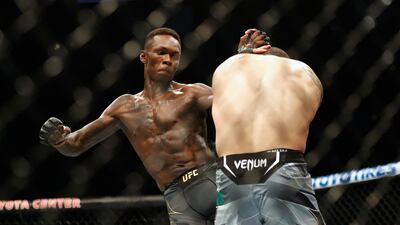 Israel Adesanya, left, lands a kick on Robert Whittaker during their middleweight title bout at UFC 271 at Toyota Center. USA Today