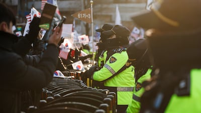 Police officers stand guard as supporters of South Korean President Yoon Suk Yeol gather near the presidential residence in Seoul on Friday. Bloomberg
