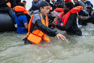 Migrants try to board a smuggler's inflatable dinghy in an attempt to cross the English Channel, in northern France last week. AFP