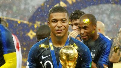 Kylian Mbappe celebrates with the World Cup trophy. Reuters