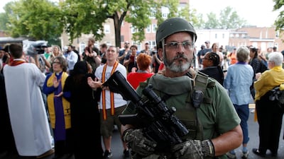 A white supremacist militia member stands in front of anti-racism protesters during the rally in Charlottesville, Virginia. Joshua Roberts / Reuters