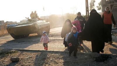 Civilians walk past Iraqi forces as they flee Mosul's southeastern Al Mithaq neighbourhood on January 3, 2017, during an ongoing military operation against Islamic State (IS) group jihadists. / AFP / Ahmad MOUSA