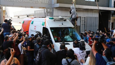 The ambulance carrying Diego Maradona drives out of the Clinica Olivos in Vicente Lopez. Getty