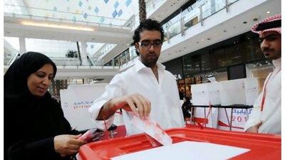 Bahrainis cast their ballots at a polling station inside a shopping mall in Manama. Just over half of eligible voters participated in Bahrain's by-elections. MAZEN MAHDI / EPA