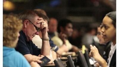 Stranded passengers wait for assistance at the Qantas Airlines counter Saturday at Los Angeles International Airport in California. A government-appointed tribunal today ordered Qantas to start flying again.