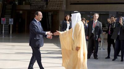 French President Francois Hollande, left, welcomes Sheikh Sultan bin Tahnoon, centre right, chairman of the Abu Dhabi Tourism and Culture Authority as he arrived for a visit of the exhibition “Birth of a museum” at the Louvre museum in Paris. Alain Jocard/EPA