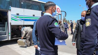 Tunisian border policemen follow up the repatriation of Tunisian workers stranded in Libya as they board buses at the Ras Jedir border post to return to their country. AFP