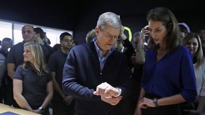 Apple CEO Tim Cook and Christy Turlington Burns, founder of Every Mother Counts, look at the new Apple Watch. She will train for the London Marathon wearing one. Eric Risberg / AP Photo