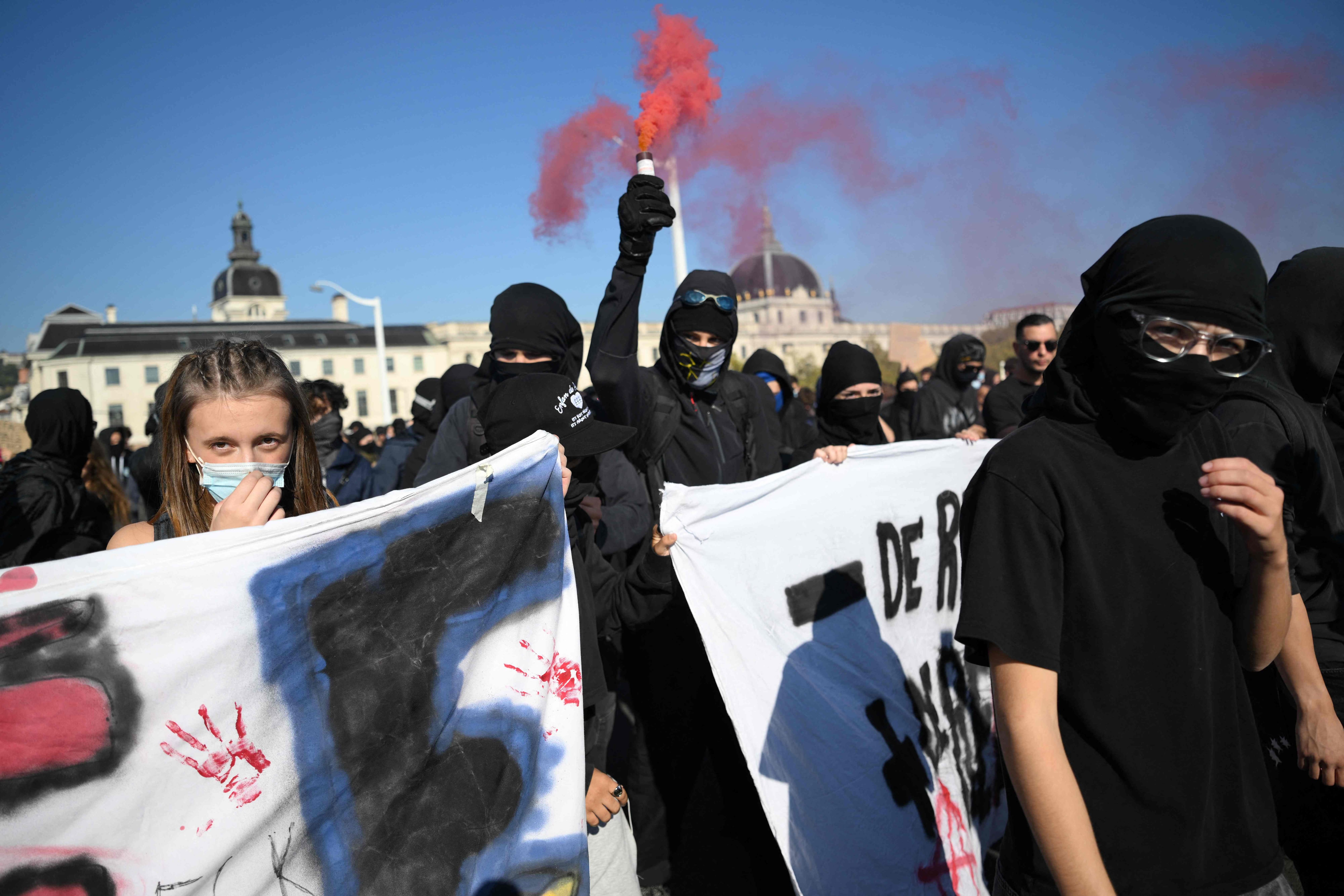 A protester lights a flare during a demonstration by French youths, part of a nationwide protest movement over education conditions, in Lyon. AFP