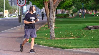 An Abu Dhabi resident goes for a jog along the Corniche in the capital as the government eases movement restrictions. Victor Besa / The National