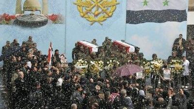 Snow falls as Syrian soldiers carry coffins of their colleagues during a funeral ceremony in Damascus Saturday.