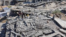 Displaced children stand on the rubble of destroyed houses as they watch food being prepared on the rooftop in the northern Gaza Strip. AFP