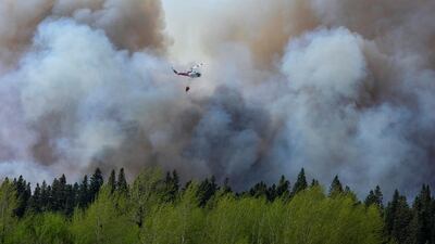 A helicopter drops water on a forest fire in Prince Albert, Saskatchewan, Canada. Reuters