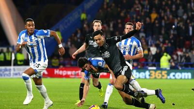 Dwight McNeil is tackled by Christopher Schindler during the Premier League match between Huddersfield Town and Burnley FC. Getty Images