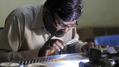 An old print being inspected by Kiran A Dhiwar, film preservation officer at the National Film Archive of India. Subhash Sharma for The National