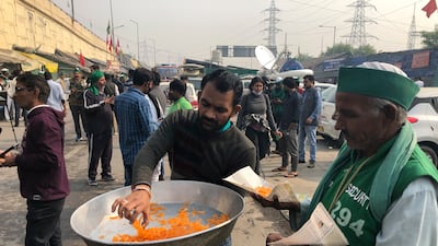 A man distributes sweets to celebrate news of the repeal of farm laws they were protesting against, in Ghazipur, on the outskirts of New Delhi on November 19, 2021. AP Photo