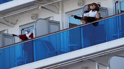 Passengers talk to each other on the balconies of their cabins on the cruise ship Diamond Princess, where dozens were tested positive for coronavirus on February 11 in Yokohama, Japan. Doctors suspect a super spreader may be responsible for the exponential growth of cases on board the ship.